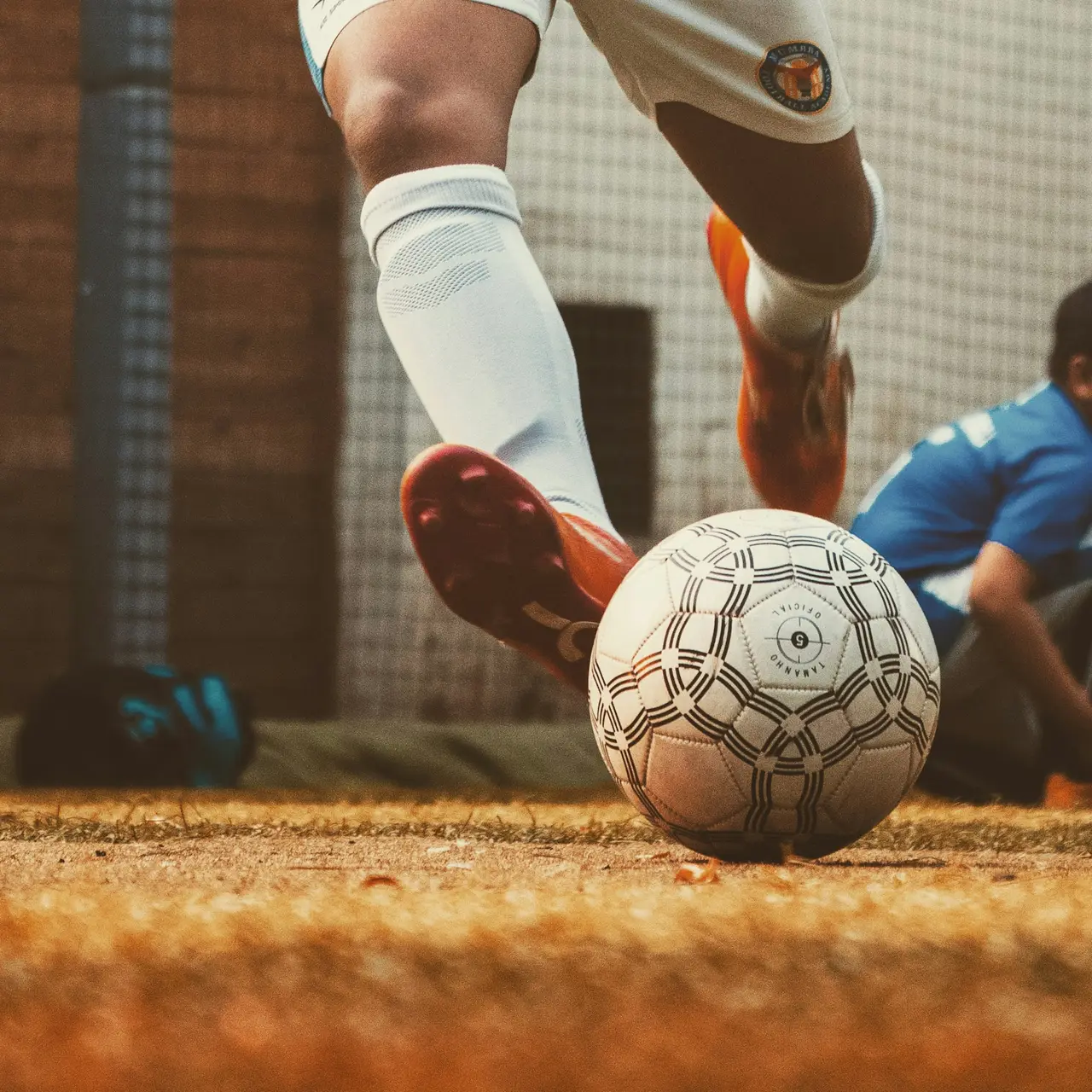 A sliding tackle for the ball in a football cage