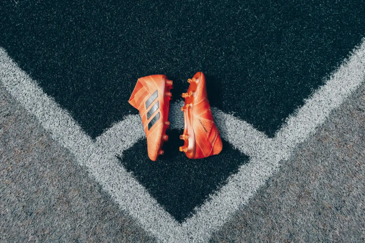 Orange football boots in the corner of an artificial pitch